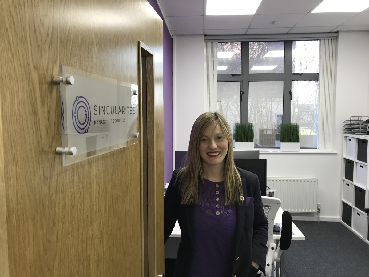 A Singularitee team member at the door of their office at Hope Park