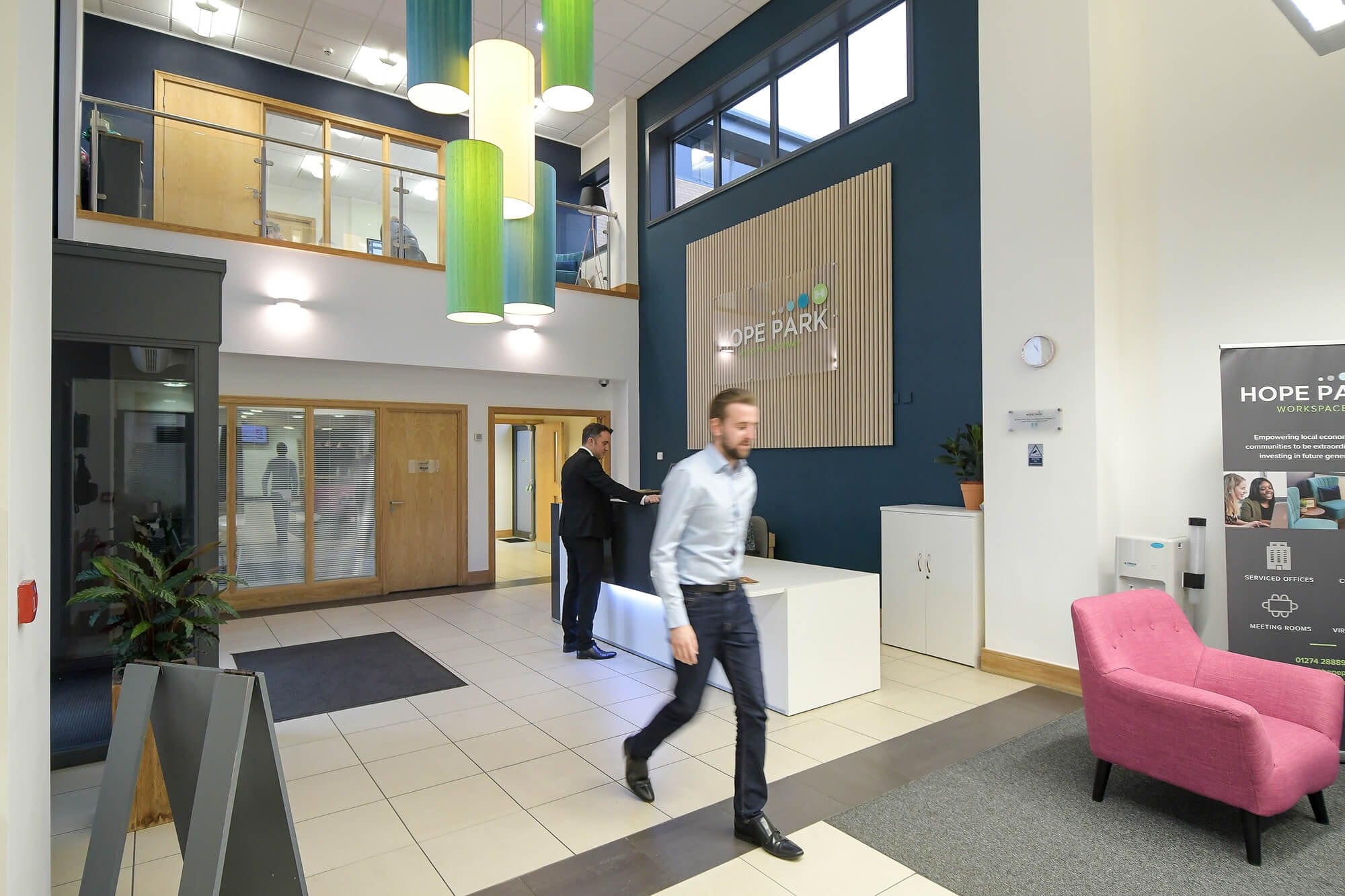Double-height entrance hall and reception with green pendant lights at Hope Park City Gateway, Bradford