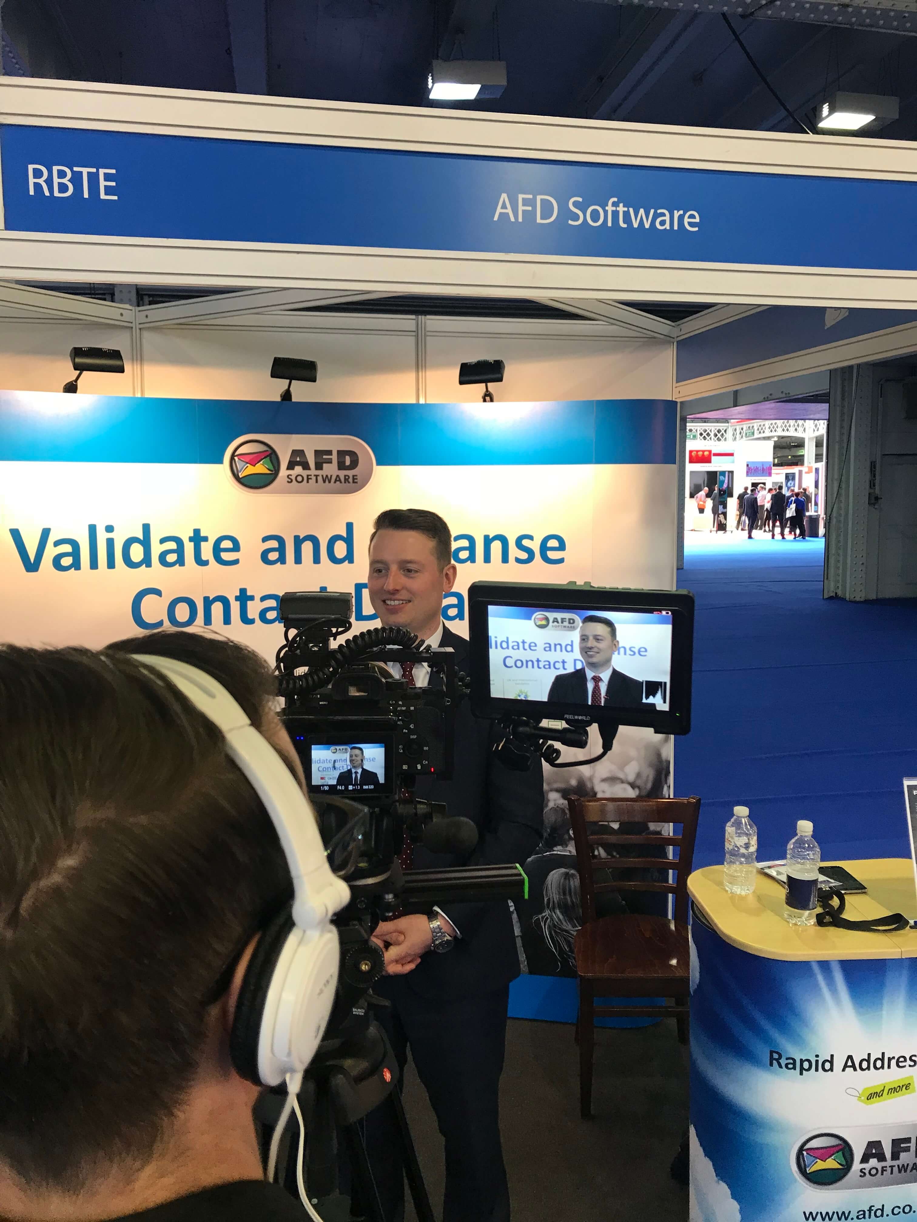AFD Software team member being filmed at their exhibition stand