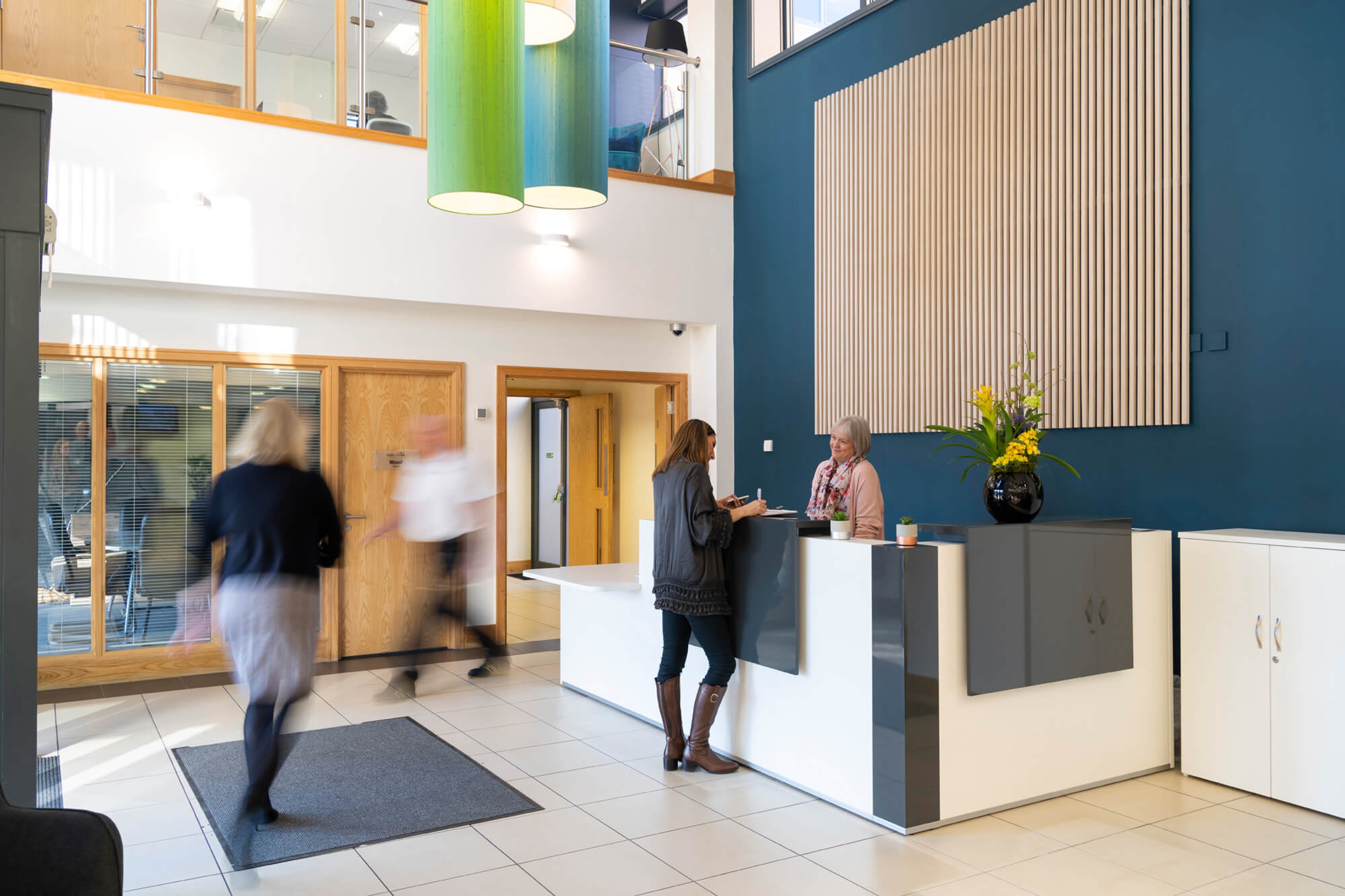 The atrium reception at Hope Park, with people walking through a bright, double-height lobby
