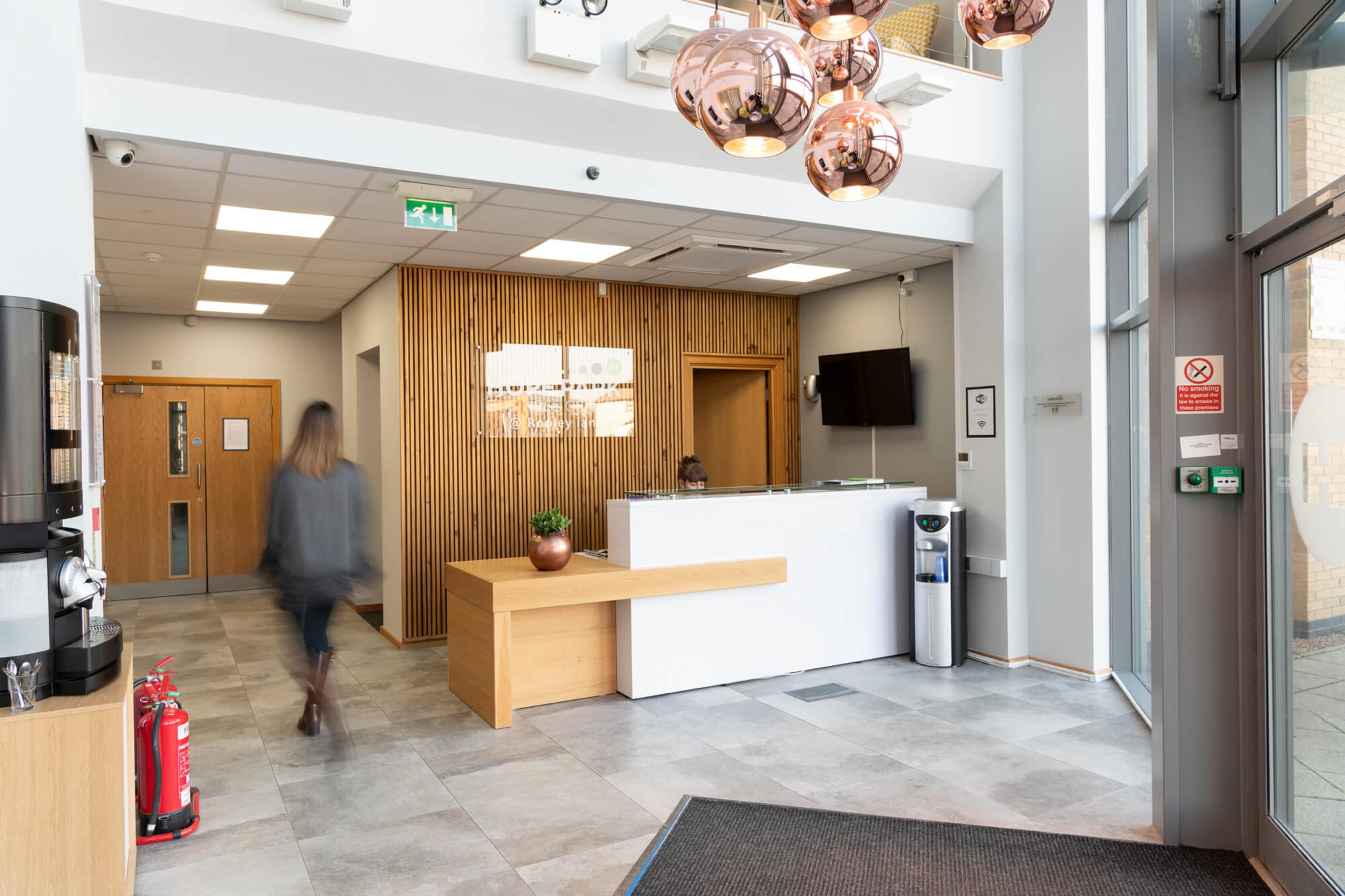 The double-height lobby and reception at City Gateway with a green accent chair