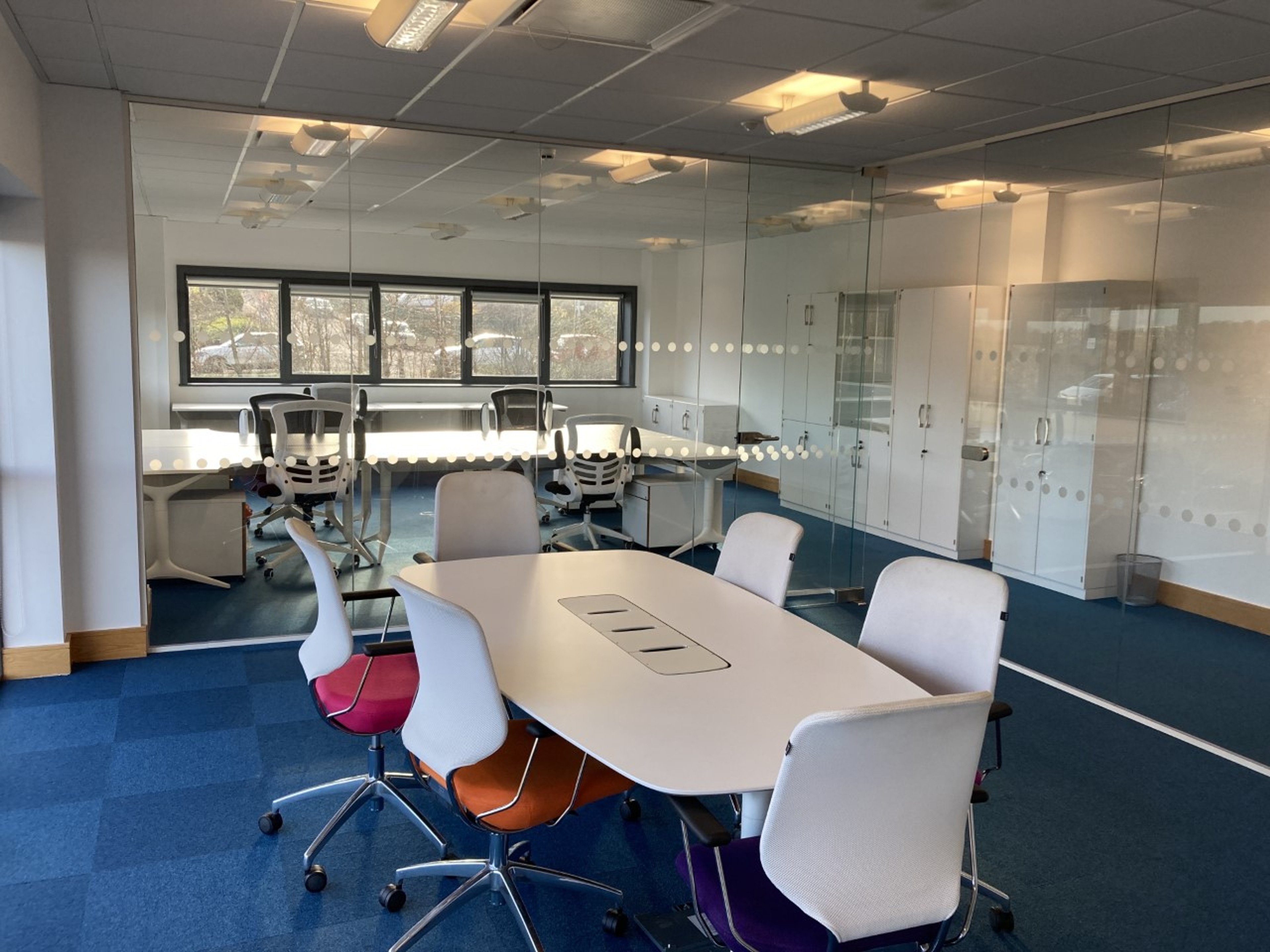 White boardroom table with six chairs in the glass meeting room of the 10-15 person office at Hope Park City Gateway, Bradford